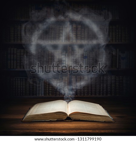 The old mysterious book and the smoke coming out of it is a sign of the pentagram. Occult, esoteric, divination, magic concept background.