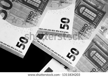 Fifty euro banknotes on a dark background close up. Black and white