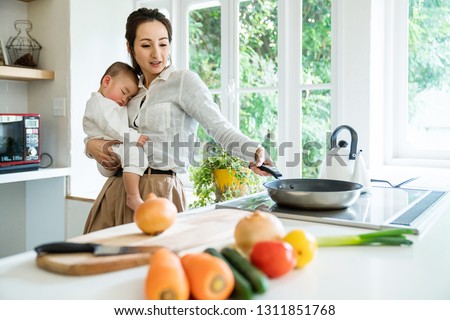 Mother and baby in the kitchen. Royalty-Free Stock Photo #1311851768