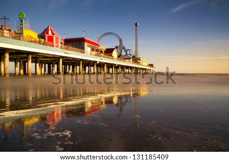 Long exposure view of the Galveston Pleasure Pier at twilight showing a smooth ocean and carnival rides in motion Royalty-Free Stock Photo #131185409