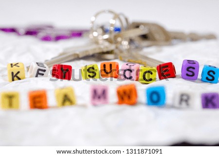 Colorful cube bead "key success" word concept word real key are behind word key success  and word teamwork in front of with white paper background,
