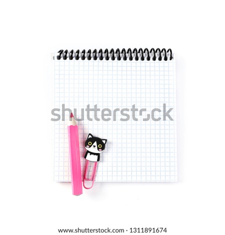 pencil and paper clip on notebook. funny school or office stationery. blank sheet of notebook. tool for creativity and school. minimal kawaii style. Flat lay, top view. copy space