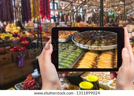 travel concept - visitor photographs of local products in city market in Pyatigorsk in Caucasian Mineral Waters region of Russia on smartphone