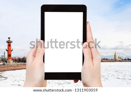 travel concept - tourist photographs of Spit of Vasilyevsky Island with Rostral Column and Peter and Paul Fortress in Saint Petersburg on smartphone with cutout screen with blank place for advertising