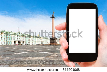 travel concept - tourist photographs of Palace Square in Saint Petersburg city in March on smartphone with empty cutout screen with blank place for advertising
