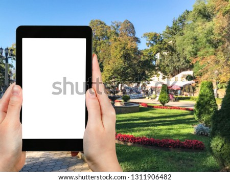 travel concept - tourist photographs of Kurortnyy bulvar in Kislovodsk resort town in Stavropol Krai of Russia in september on smartphone with cut out screen with blank place for advertising