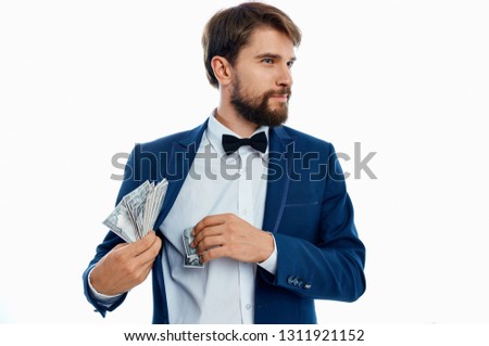 A man in a blue jacket hides money and looks to the side