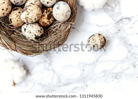 Easter decoration with egg in nest and cotton on white marble background. Easter concept. Flat lay top view copy space. Spring greeting card