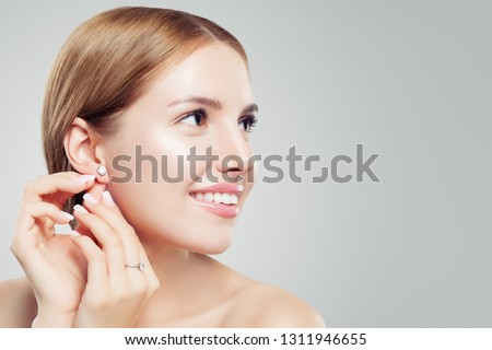 Women earring jewelry model. Cheerful woman with diamond earrings and ring, beautiful face closeup Royalty-Free Stock Photo #1311946655