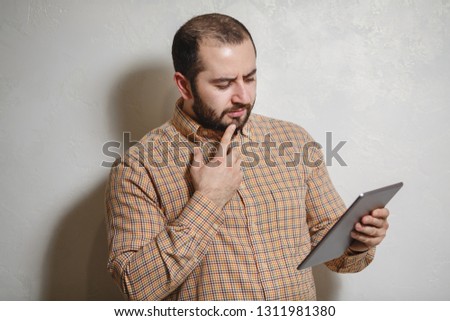 Happy man with a modern smartphone in his hands, playing in games. The man with a smile and beauty shows different emotions on a white background.