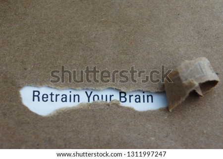 Torn paper with text retrain your brain