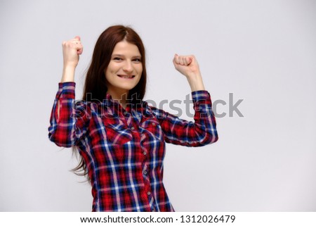 Concept studio portrait of a beautiful young beautiful brunette girl on a white background with different emotions in multi-colored shirt. She stands directly in front of the camera in various poses.
