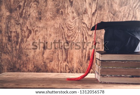 Graduation hat with books on table. Education concept