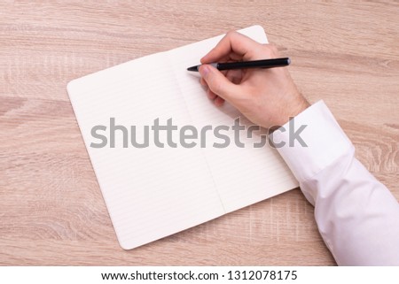 Office, a man writes in a notebook