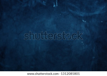 The background of the stucco wall is dark blue. wall texture rough abstract decorated in blue.