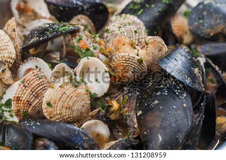 A bowl of mussels and other different shellfish.