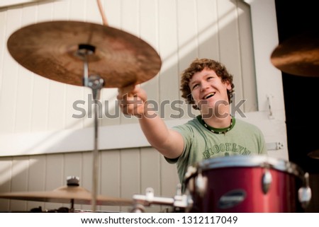 Teenage boy playing the drums during drum practice.