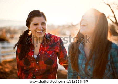 Two young farm workers laughing together.