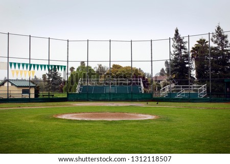Empty baseball field surrounded by a high fence.