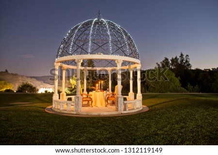 Romantic table for two set up in a gazebo.