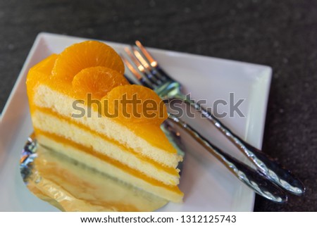 Orange pie cake and forks on white disk