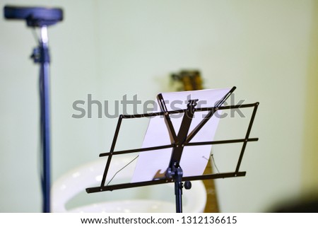 Royalty high quality free stock photo of music stand with microphone and guitar in blurred background 