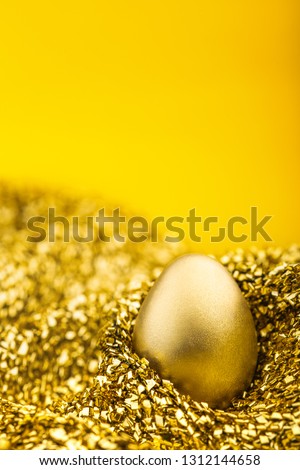Image of shiny golden egg on golden fabric