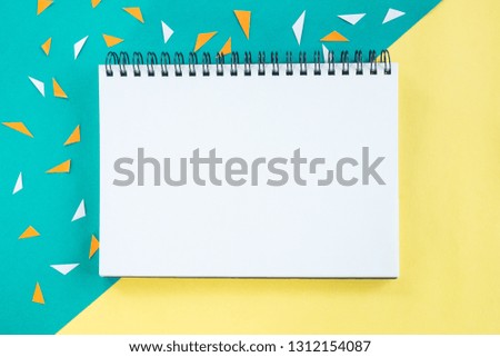 Open blank notepad on colorful paper background