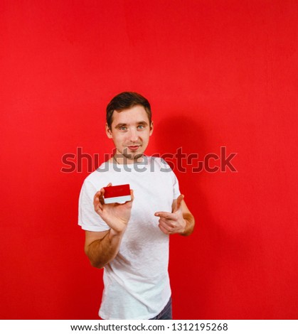 A man recommending a red bank card in red background.