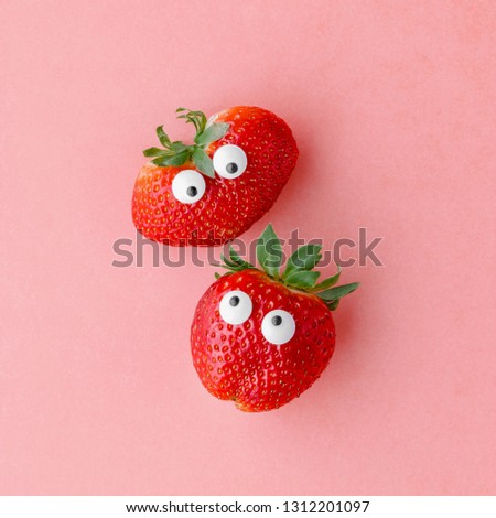 Funny face strawberries on a pink background, creative healthy food concept, top view