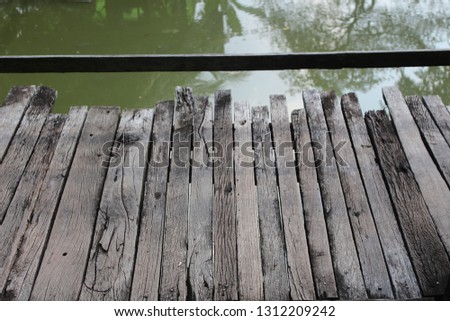 The bridge is made of natural wood panels that are very old.