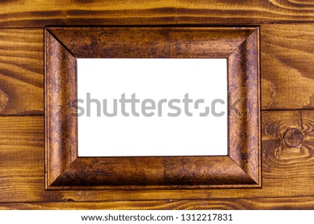 Empty photo frame on wooden background. Top view