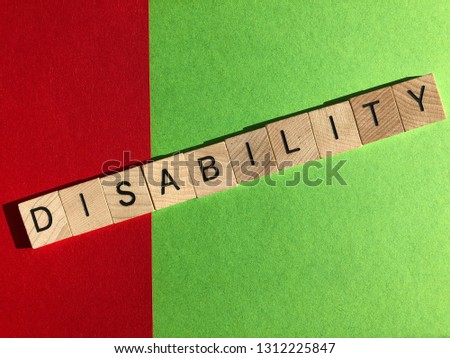 Disability concept. Wooden letters, on red and green, splitting the word in to the negative and positive, dis and ability