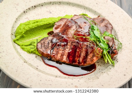 steak with pea sauce and mashed potatoes