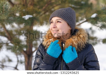 Winter young woman portrait. Beauty Joyful Model Girl laughing and having fun in winter park. Beautiful young female outdoors, Enjoying nature, wintertime