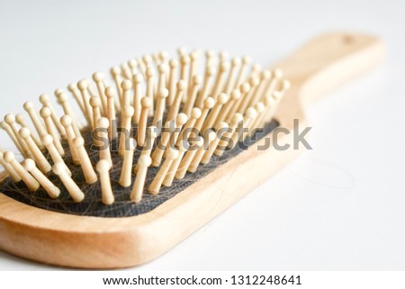 Wooden hair comb with fallen hair on white background stock photo