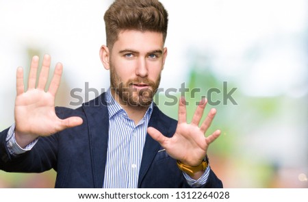Young handsome bussines man Smiling doing frame using hands palms and fingers, camera perspective