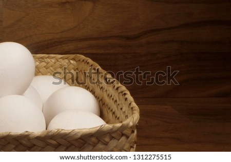 A basket of fresh white chicken eggs.