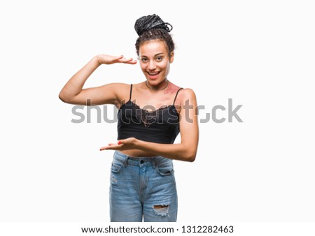 Young braided hair african american with pigmentation blemish birth mark over isolated background gesturing with hands showing big and large size sign, measure symbol. Smiling looking at the camera