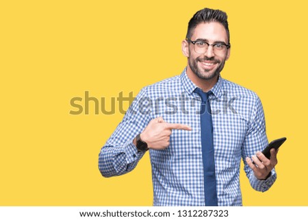 Young business man using smartphone over isolated background very happy pointing with hand and finger