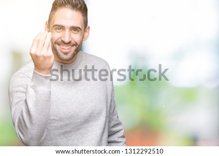 Young handsome man wearing sweatshirt over isolated background Doing Italian gesture with hand and fingers confident expression