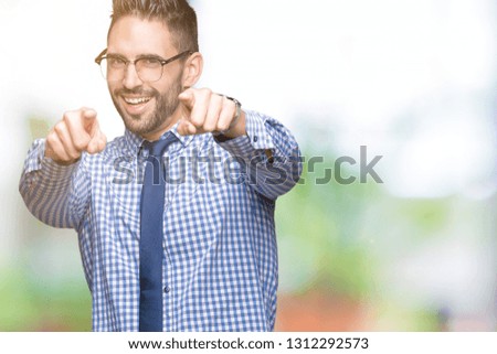 Young business man wearing glasses over isolated background Pointing to you and the camera with fingers, smiling positive and cheerful