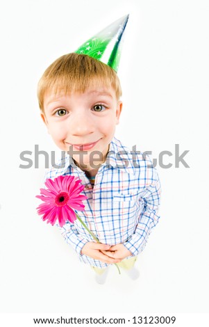 Image of happy boy with a cap holding the flower at his birthday