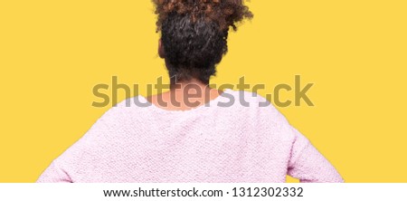 Beautiful young african american woman wearing glasses over isolated background standing backwards looking away with arms on body