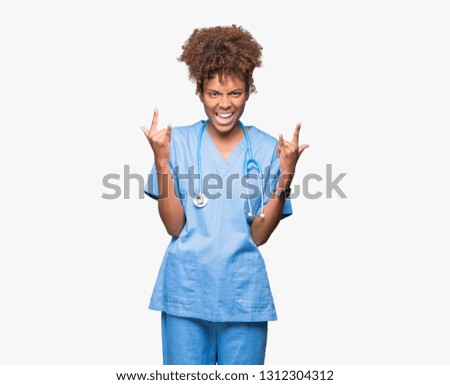 Young african american doctor woman over isolated background shouting with crazy expression doing rock symbol with hands up. Music star. Heavy concept.