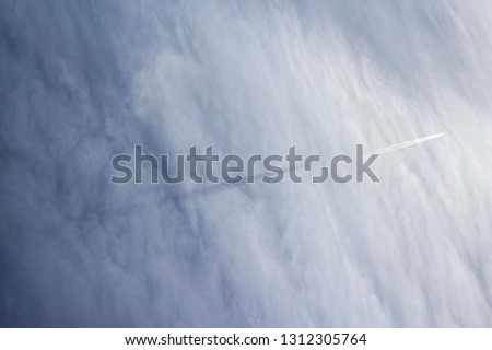 Trail of the plane in the sky. Avia transportation. International flight. Passenger aircraft in the sky. Background for the airline company. Soft background of clouds. The sky in the clouds.