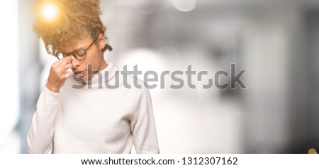 Beautiful young african american woman wearing glasses over isolated background tired rubbing nose and eyes feeling fatigue and headache. Stress and frustration concept.