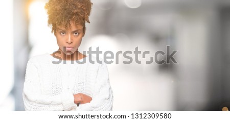 Beautiful young african american woman wearing winter sweater over isolated background skeptic and nervous, disapproving expression on face with crossed arms. Negative person.