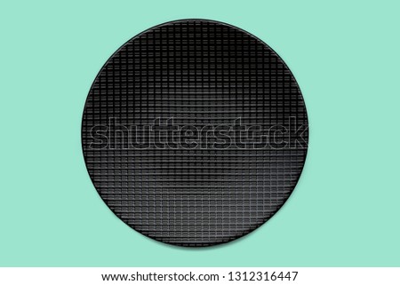 Black plate on mint green colored background, clipping path included, view directly from above