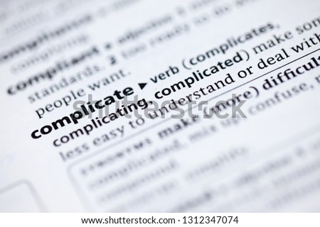 Blurred close up to the dictionary definition of Complicate